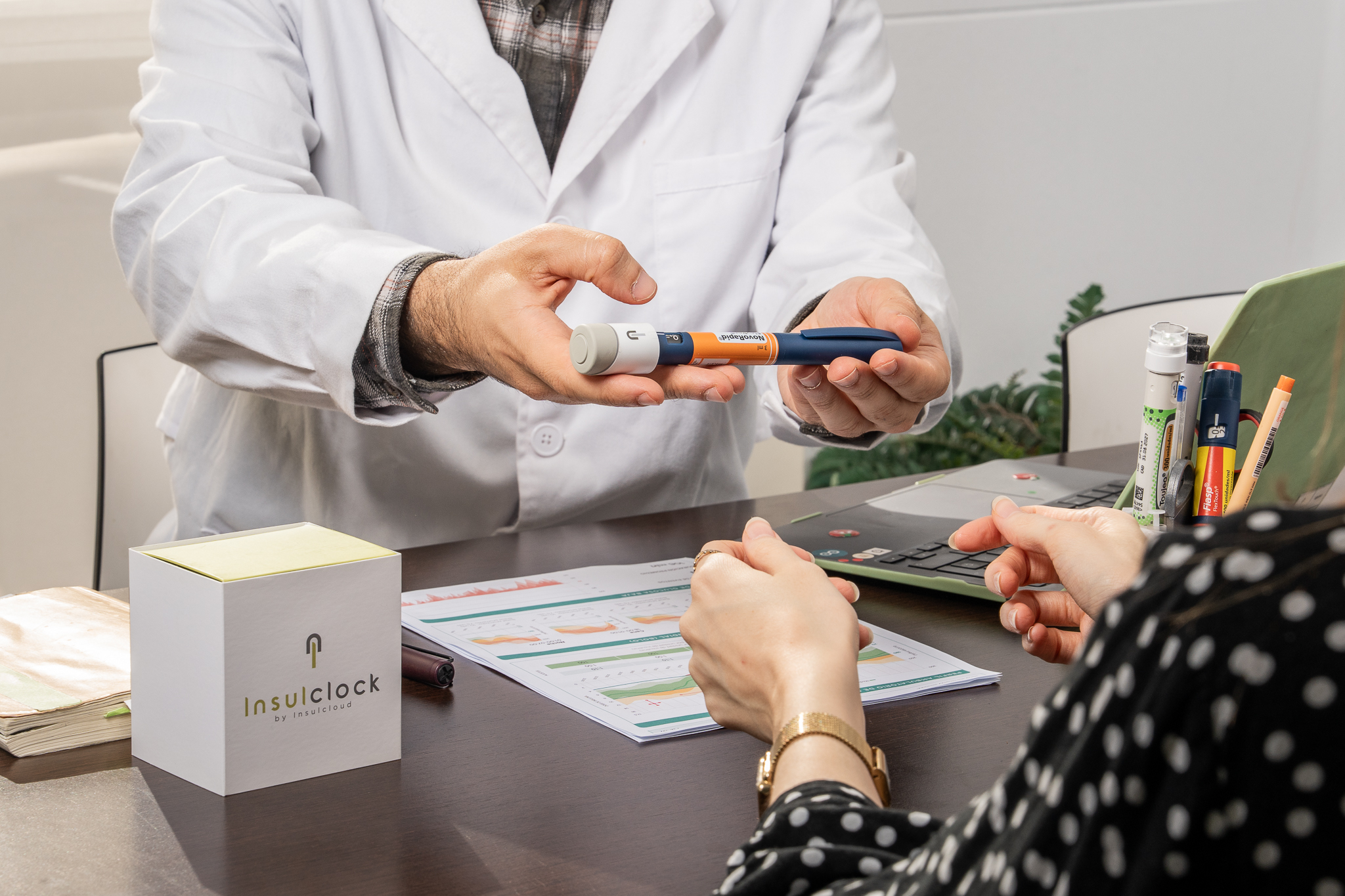 Profesional sanitario entregando una pluma de insulina a un paciente